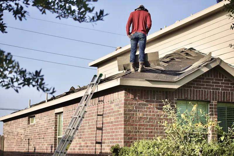 Professional roofer working on a residential roof in Alessandro